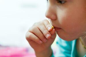 Portrait of a little girl eating a chocolate candy photo