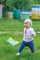 baby on apiary. girl carries flag of Ukraine along hives on apiary. Celebration of Ukraine's Independence Day. photo