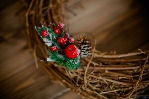 Christmas rustic wicker nest with red berries on wooden background. photo