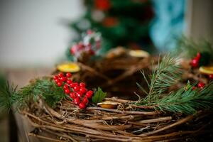 Christmas rustic wicker nest with red berries on wooden background. photo