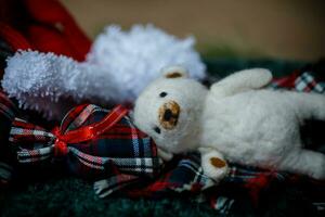 Santa Claus hat and teddy bear on a plaid fabric. photo