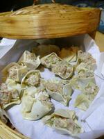 Steaming shumai dim sum in a bamboo steamer photo