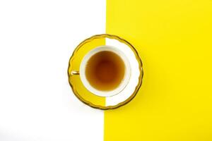 amarillo té taza en un blanco y amarillo antecedentes foto