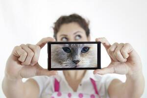 hermosa joven mujer toma un selfie y volverse un gato foto