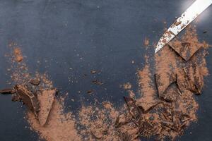 dark chocolate pieces mixed with cocoa powder photo