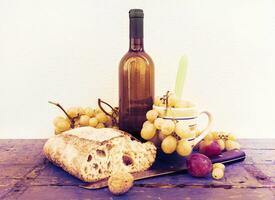un pan uvas y un botella de vino terminado de madera tableros foto