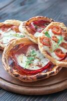 Mini pizzas on the wooden board photo