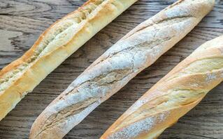 Three baguettes on the wooden background photo