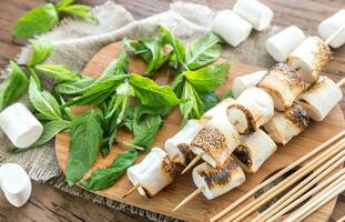 Marshmallow skewers on the wooden board photo