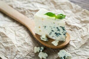 Piece of the blue cheese on the wooden spoon photo