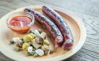 Grilled sausages with marinated vegetables photo