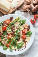 Crepes with cherry tomatoes, cheese, mushrooms and arugula photo