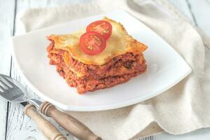 Portion of lasagne on the white plate photo