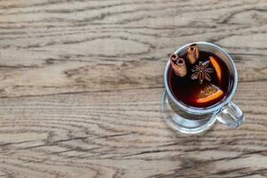 Glass of mulled wine on the wooden background photo