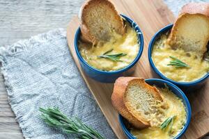 Bowls of onion soup on the wooden board photo