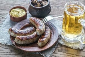 Grilled sausages with fried bacon rashers and mushrooms photo