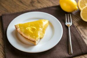 Slice of lemon tart on the plate photo