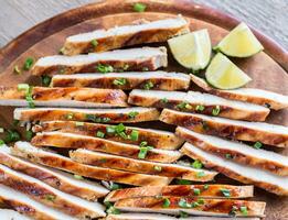 Slices of grilled chicken in lime sauce photo