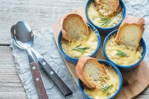 Bowls of onion soup on the wooden board photo