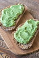 Slices of toasted bread with avocado paste photo