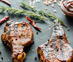 A la parrilla Cerdo costillas en el de madera antecedentes foto