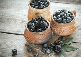 Bowl of blackberries on the wooden table photo