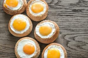 Egg-in-a-hole buns on the wooden board photo