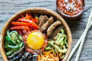 Bowl of bibimbap on the wooden table photo