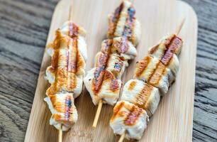 Grilled chicken skewers on the wooden board photo