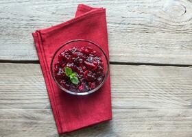 Bowl of cranberry sauce on the wooden board photo