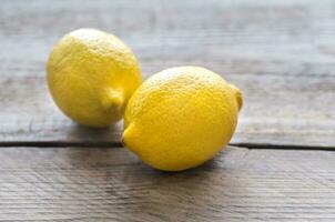 Fresh lemons on the wooden background photo