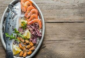 Fresh seabass with seafood on the tray photo