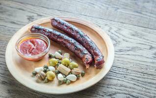 Grilled sausages with marinated vegetables photo
