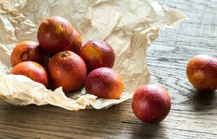 Red tangerines on the wooden background photo