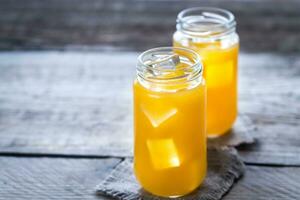 Glass jars of mango juice photo