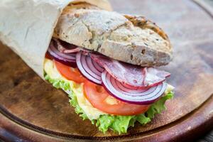 Sandwich with ham, cheese and fresh vegetables photo