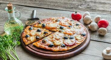 Cooked pizza on the wooden board photo