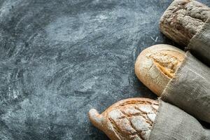 Whole grain breads on the dark wooden background photo