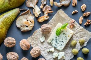 Blue cheese with walnuts, oyster mushrooms and green olives photo
