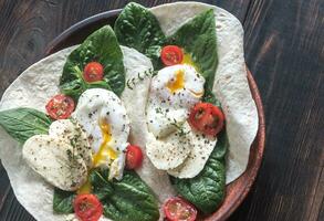 Tortilla sandwiches with poached eggs photo