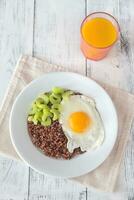 Portion of red quinoa with fried egg and celery photo