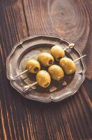 Olive skewer on the vintage plate photo