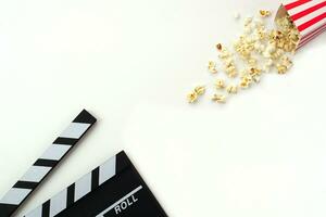 Clapperboard or movie slate black color with popcorn on white background. Cinema industry, video production and film concept. photo