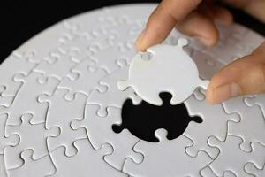 Hand put the last piece of jigsaw puzzle to complete the mission, Business solutions, success and strategy concept, The solution includes completing the mission. photo