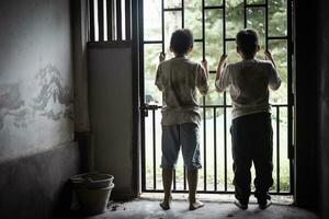 Children who were imprisoned in a room with a steel cage. The concept of stopping violence against children and human trafficking. photo