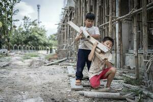 Concept of child labor, poor children being victims of construction labor, human trafficking, child abuse. photo