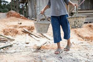 Children forced to work hard at construction site, child labor concept, poor children victims of human trafficking process, poverty, child abuse. photo