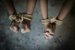 Hopeless man hands tied together with rope,  child labor concept, poor children victims of human trafficking process, poverty, child abuse. photo