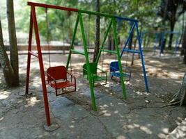 swing in the garden, empty swings in the playground, colorful swings in the park photo