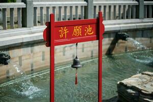 Singapore - June 11 2023. Chinese Bell Structure in Pond photo